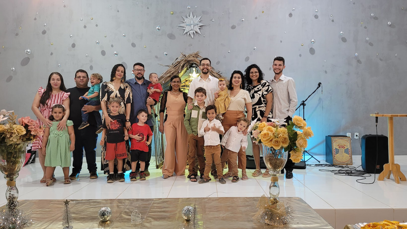 As famílias missionárias reunidas com suas crianças no salão da igreja