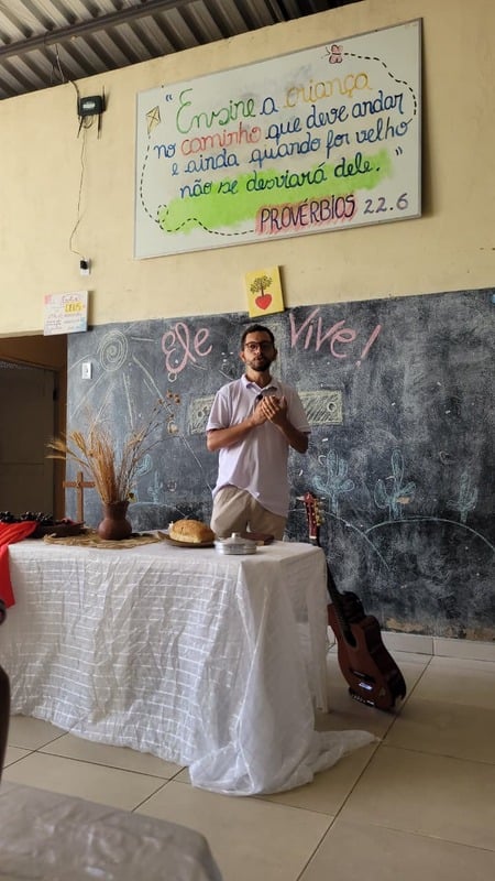 Luan diante da mesa da Ceia do Senhor, ensinando a Palavra